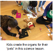 Children working on the floor with construction paper. Text under it states, Kids create the organs for their 'pets' in this science lesson.